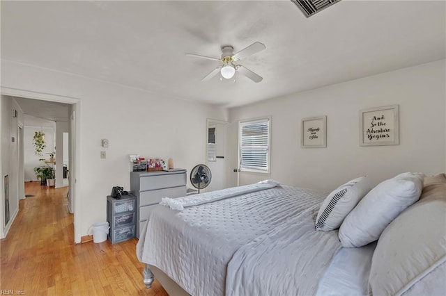 bedroom with light wood-type flooring, visible vents, and ceiling fan