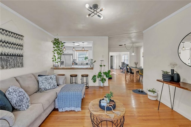 living area with baseboards, light wood-type flooring, and crown molding