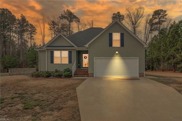 view of front facade with a garage, fence, and concrete driveway