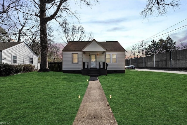 bungalow-style home with crawl space, fence, and a front lawn