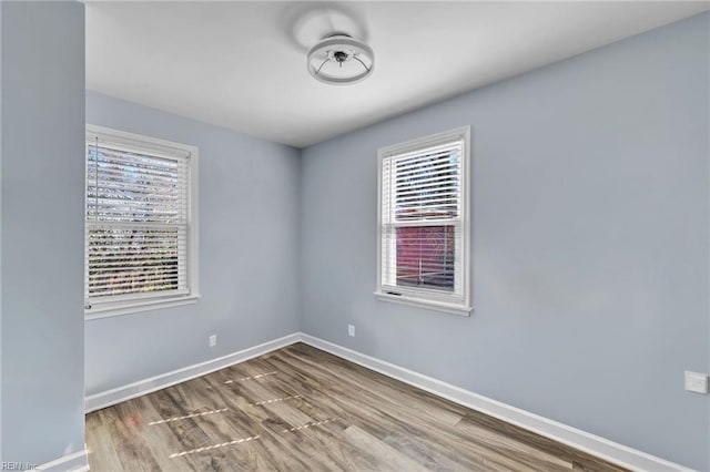 empty room featuring wood finished floors and baseboards