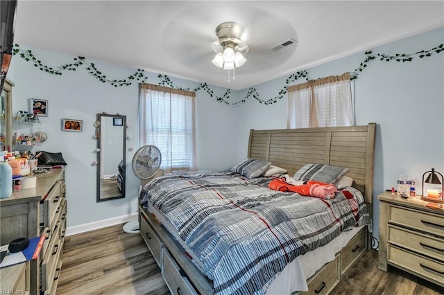 bedroom with dark wood-style floors, baseboards, and visible vents