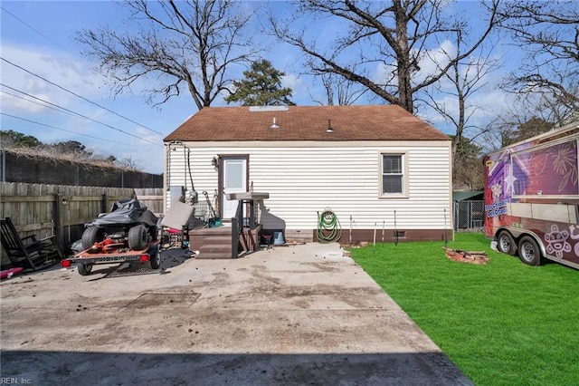 rear view of property featuring a yard, crawl space, a patio area, and fence