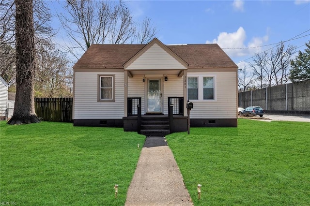 bungalow-style house with roof with shingles, crawl space, a front yard, and fence