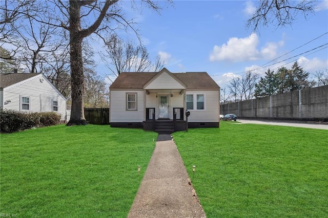 bungalow-style home with crawl space, fence, and a front lawn