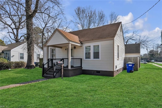 bungalow-style home with covered porch, a shingled roof, crawl space, and a front yard