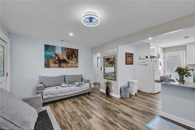 living area with recessed lighting, light wood-style flooring, and baseboards