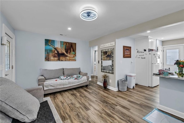 living area featuring light wood finished floors, recessed lighting, and baseboards