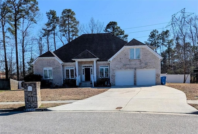 craftsman house with a garage, concrete driveway, brick siding, and fence