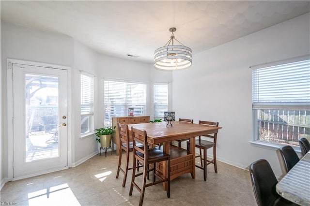 dining area featuring a chandelier, plenty of natural light, and visible vents