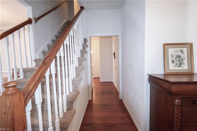 hallway featuring stairs, baseboards, and wood finished floors