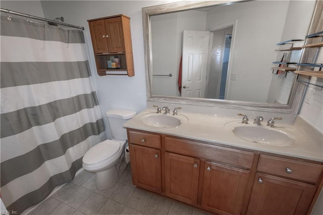 full bath featuring double vanity, tile patterned flooring, a sink, and toilet