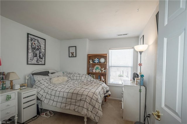 bedroom with baseboards, visible vents, and light colored carpet