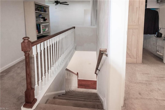 stairway with carpet flooring, a ceiling fan, and baseboards