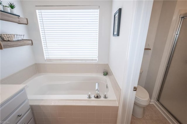 full bath with a stall shower, vanity, toilet, and a bath