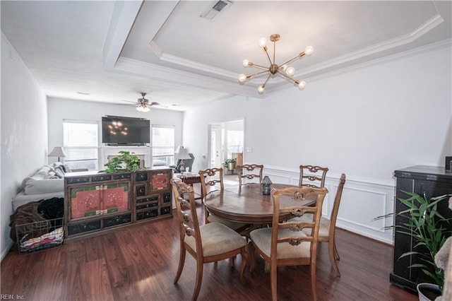 dining space with visible vents, a raised ceiling, wainscoting, ornamental molding, and wood finished floors