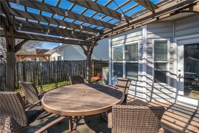 deck with outdoor dining space, fence, and a pergola