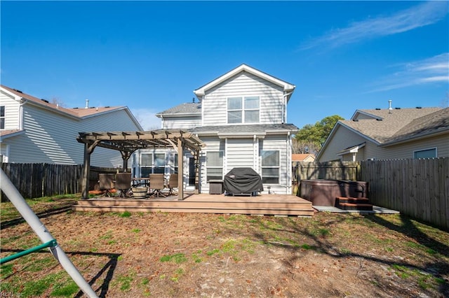 rear view of property featuring a deck, a pergola, a fenced backyard, and a hot tub