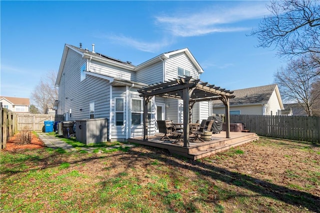 back of property with a fenced backyard, a yard, a wooden deck, and a pergola