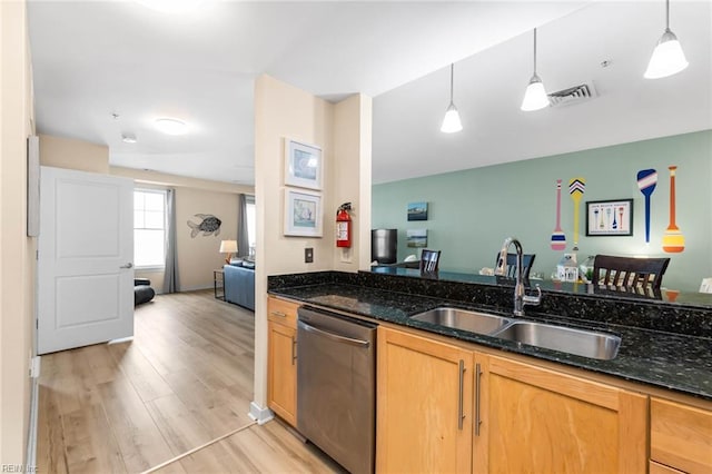 kitchen with light wood finished floors, visible vents, open floor plan, stainless steel dishwasher, and a sink