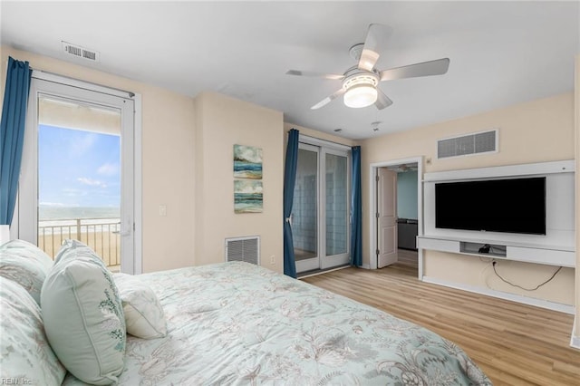 bedroom featuring access to outside, visible vents, and wood finished floors