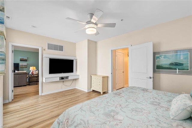 bedroom featuring visible vents, ceiling fan, baseboards, and wood finished floors