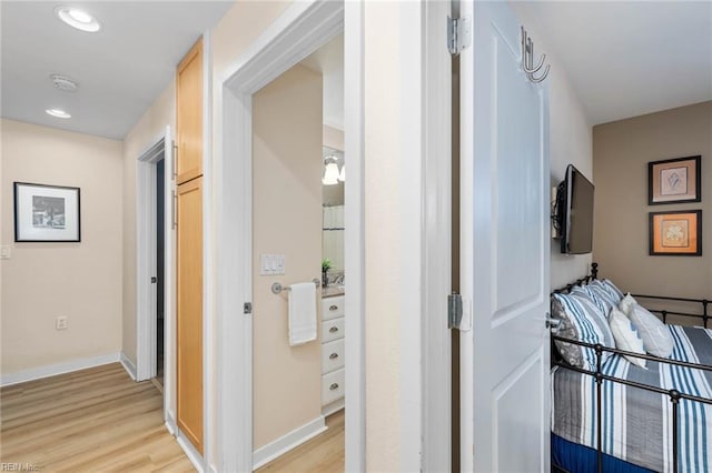 hall with light wood-type flooring, baseboards, and recessed lighting