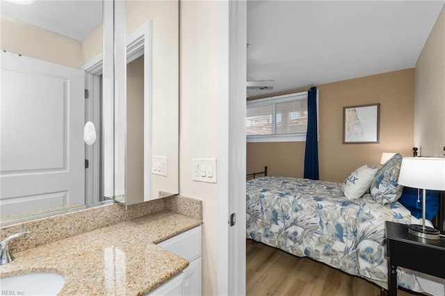 bedroom with a sink and wood finished floors