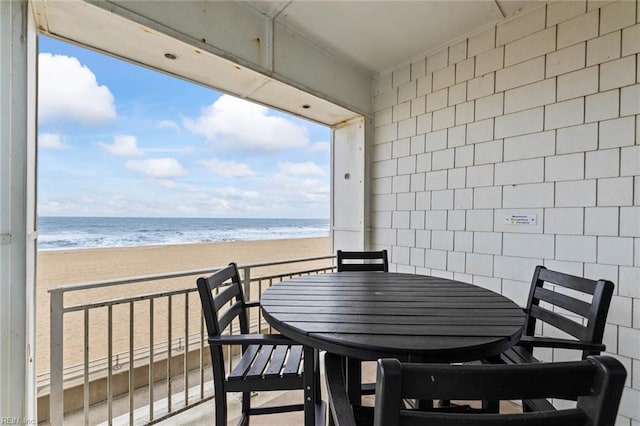 balcony featuring a beach view and a water view