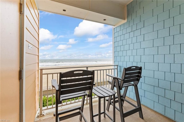 balcony with a water view and a beach view