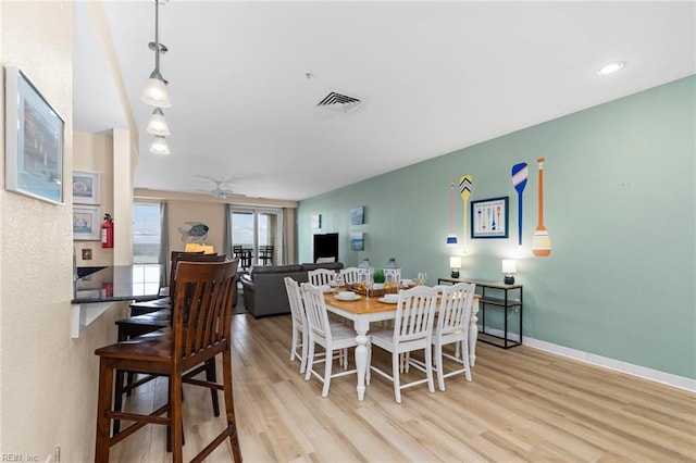 dining area with baseboards, ceiling fan, visible vents, and wood finished floors