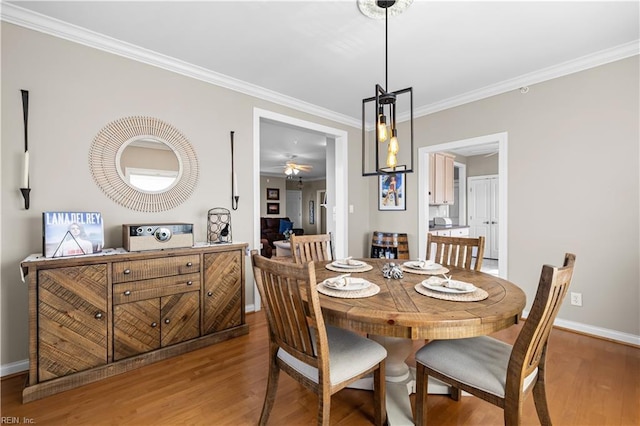 dining room featuring baseboards, wood finished floors, and crown molding