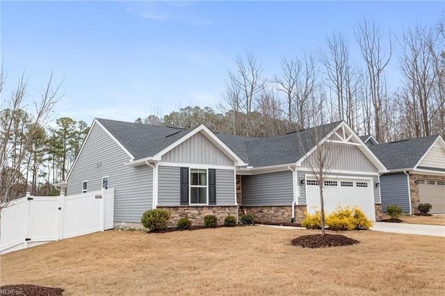 craftsman house with board and batten siding, fence, a front yard, a garage, and a gate