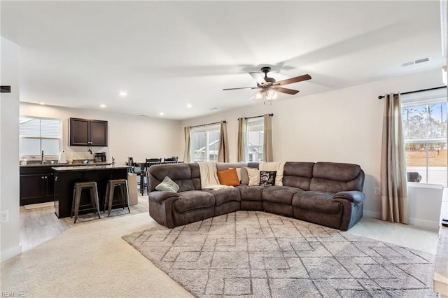 living room featuring a ceiling fan, plenty of natural light, recessed lighting, and visible vents