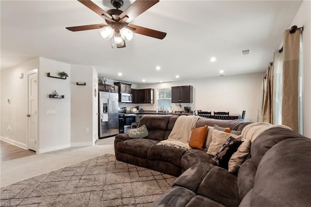 living area with visible vents, recessed lighting, baseboards, light colored carpet, and ceiling fan