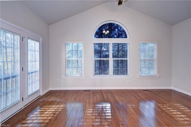 unfurnished room featuring wood-type flooring, baseboards, and vaulted ceiling