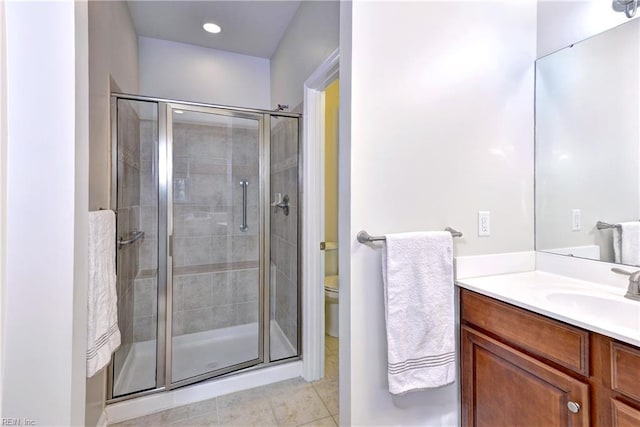 full bathroom featuring toilet, a stall shower, tile patterned flooring, and vanity