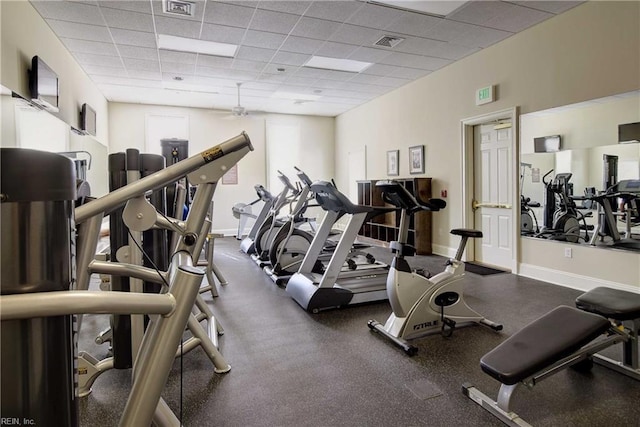 gym with a drop ceiling, visible vents, and baseboards