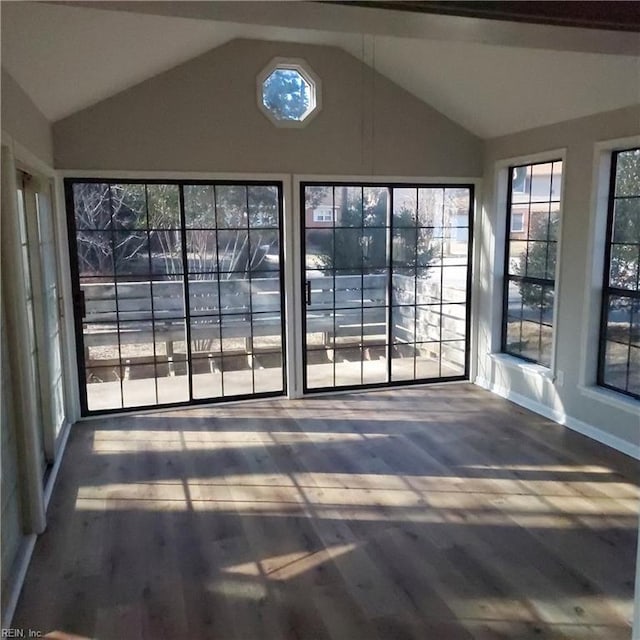 unfurnished sunroom featuring vaulted ceiling