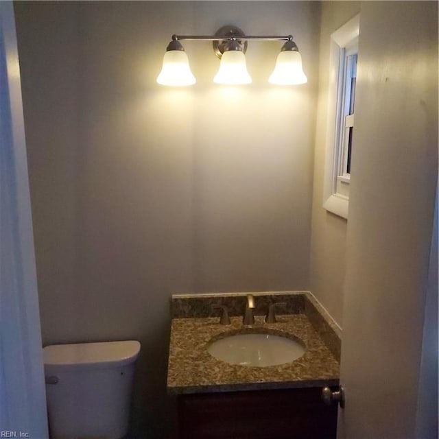 half bath featuring toilet and vanity