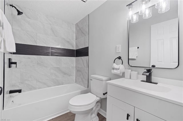 bathroom featuring toilet, tub / shower combination, a textured ceiling, vanity, and wood finished floors