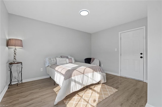 bedroom featuring baseboards and wood finished floors