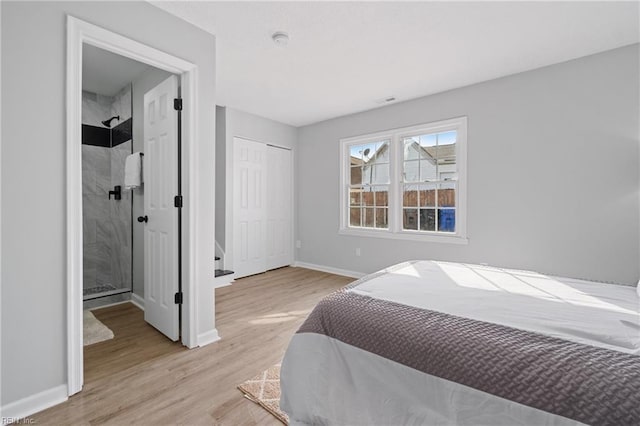 bedroom with light wood-style flooring, baseboards, and a closet