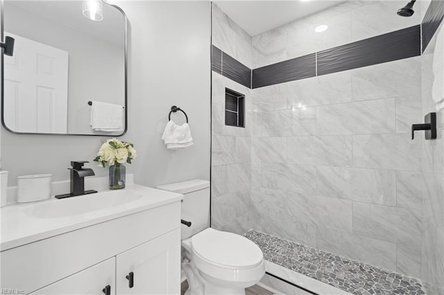 bathroom with a stall shower, vanity, and toilet