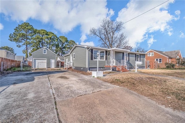 view of front of home featuring a garage, concrete driveway, fence, and an outdoor structure