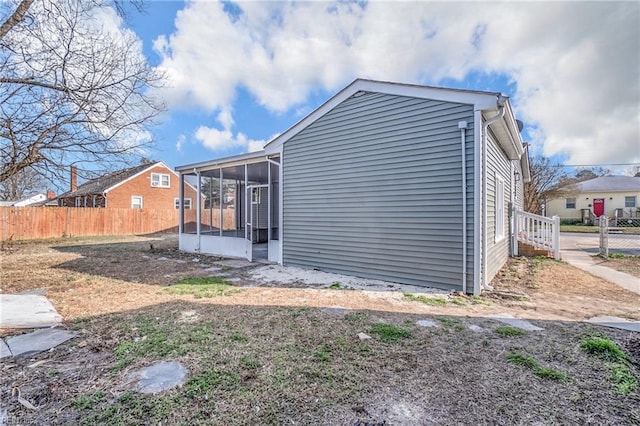 exterior space with a sunroom and fence