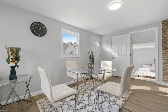 dining space featuring wood finished floors and baseboards