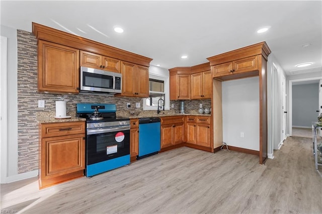 kitchen with light stone counters, brown cabinets, stainless steel appliances, light wood-style flooring, and decorative backsplash