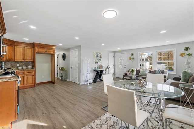 dining area with baseboards, light wood-style flooring, and recessed lighting