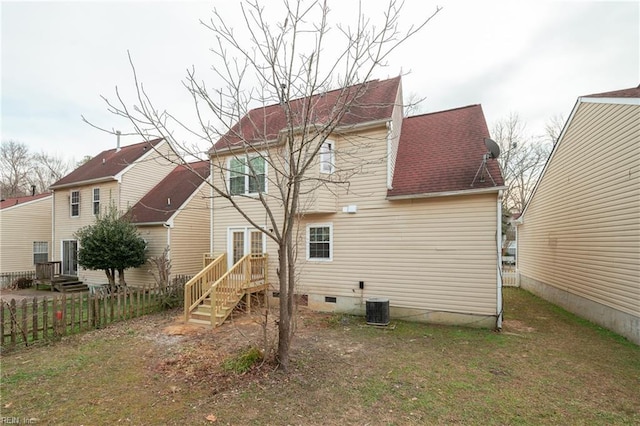 rear view of property with central air condition unit, fence, roof with shingles, crawl space, and a lawn